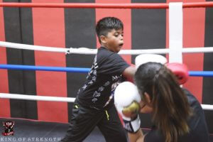 Young Boxer in Training with Coach, Emphasizing Discipline and Skill Over Violence