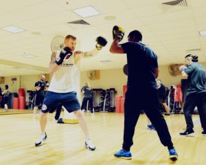 Active studio session with people participating in boxing routines and sparring