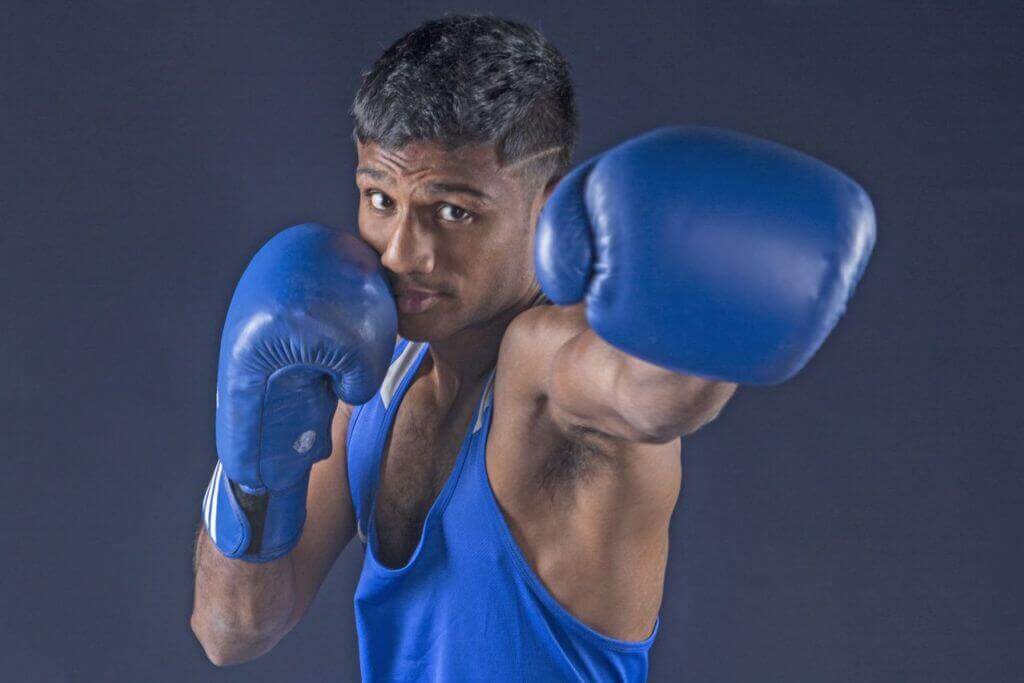 Hanurdeen striking a boxing pose with blue boxing gloves.